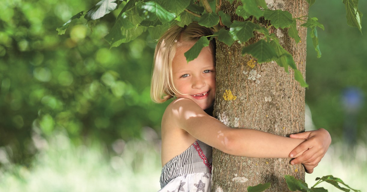 mädchen umarmt einen baum